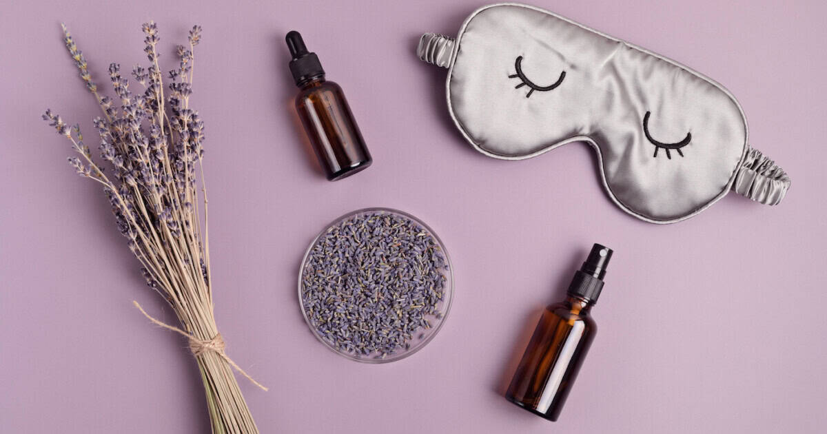 Masque de sommeil et huile essentielle de lavande sur fond violet. Traitement naturel de l'insomnie