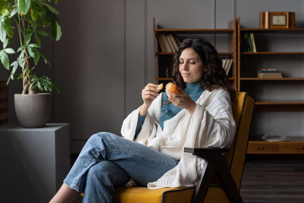 Jeune femme qui mange une clémentine