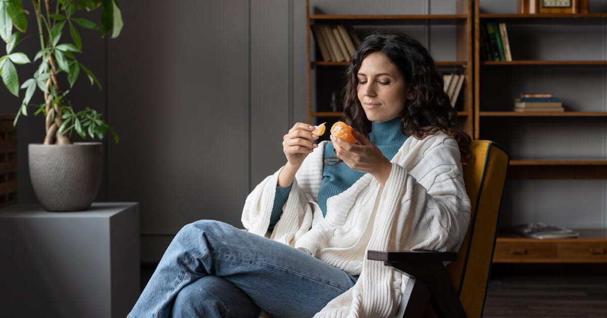 Jeune femme qui mange une clémentine