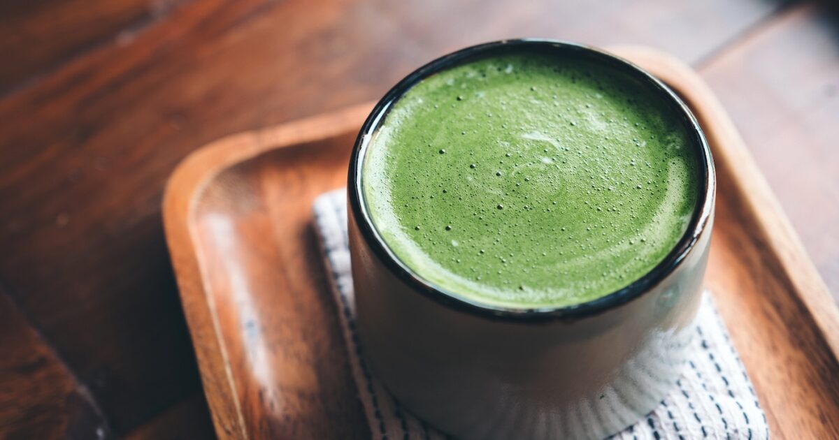 Une tasse de matcha latte chaud sur parquet