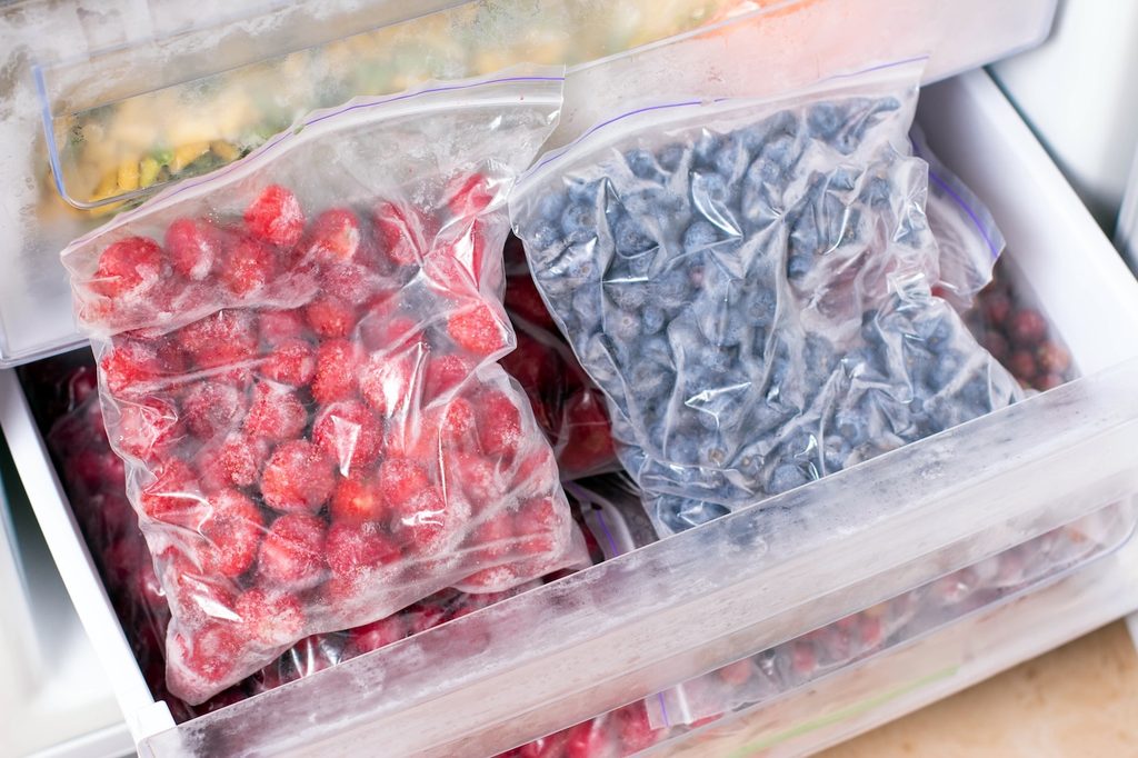 Baies sur les étagères du congélateur. Aliments surgelés au réfrigérateur