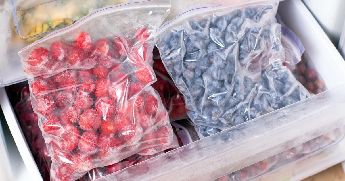 Baies sur les étagères du congélateur. Aliments surgelés au réfrigérateur