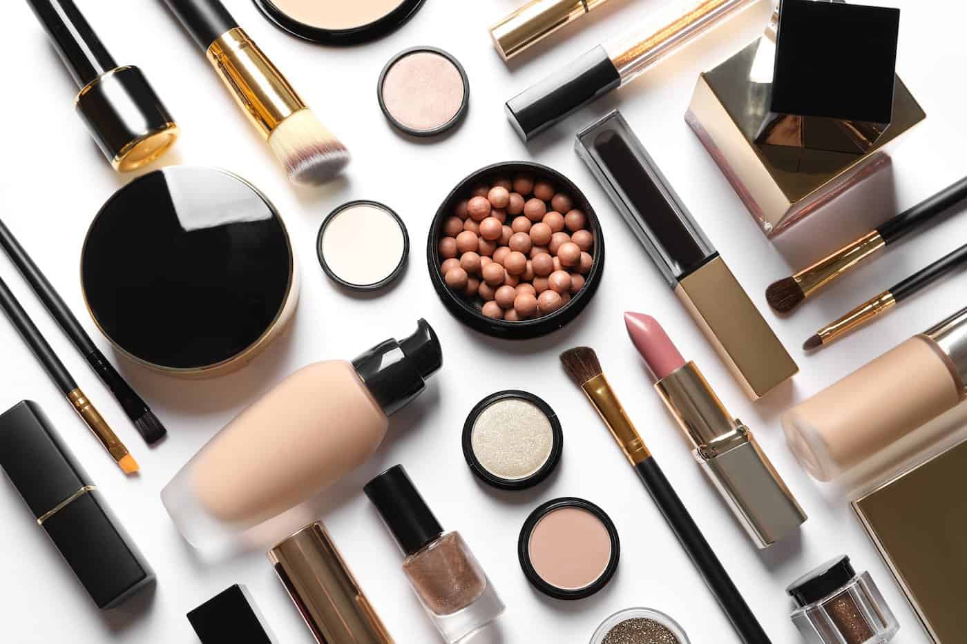 Ensemble de produits de maquillage de luxe sur fond blanc, pose plate
