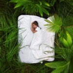 Une femme endormie dans une forêt de jungle profonde se trouve sur un matelas gonflable, vue d'en haut