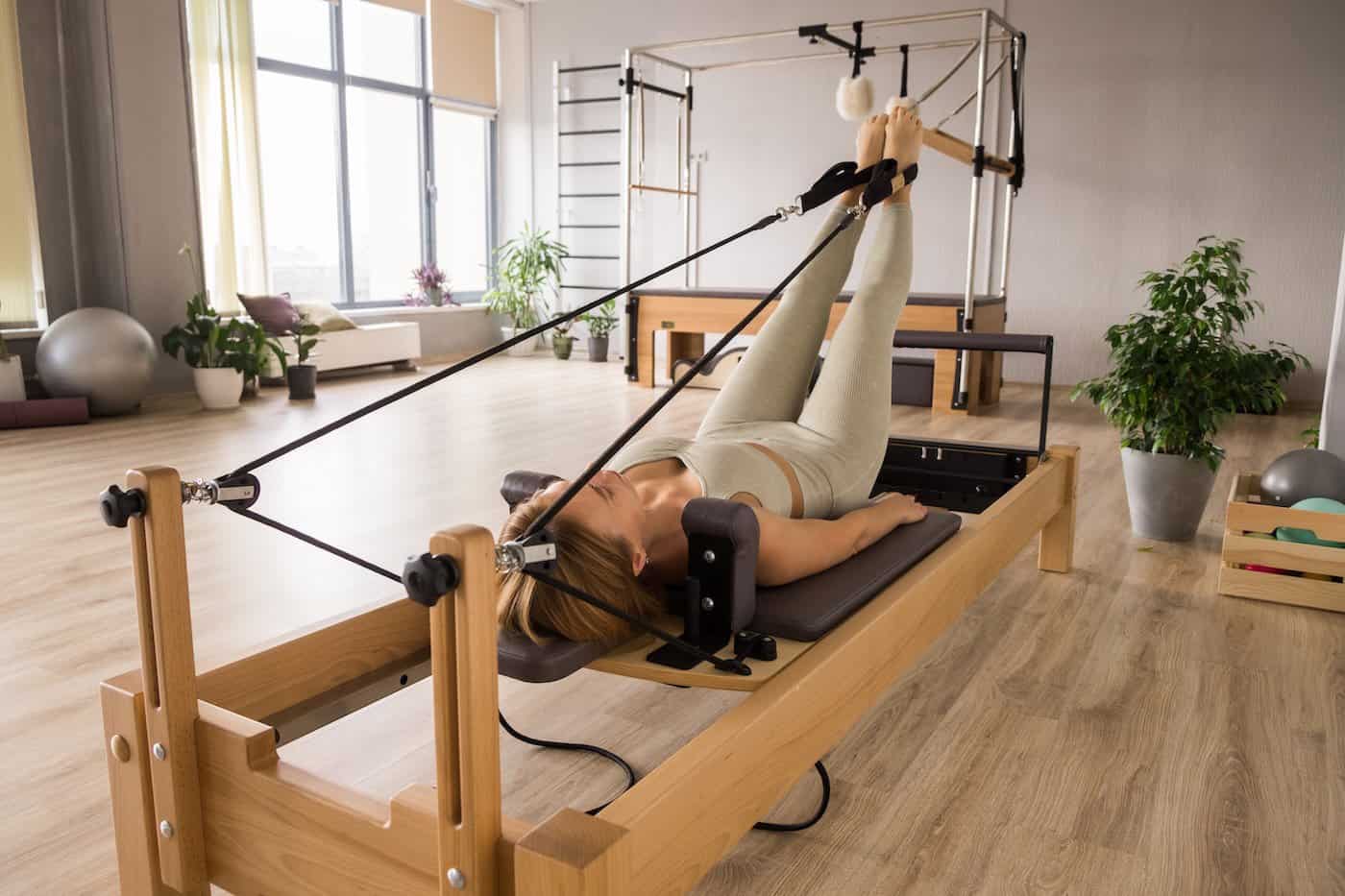 Femme s'entraînant au Pilates Reformer.